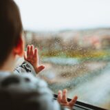 Selective Focus Photography of a Baby Looking Through The Window